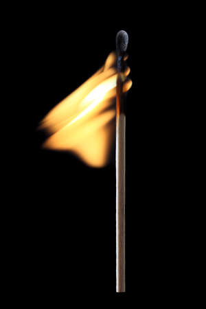 flaming match isolated on blackの写真素材