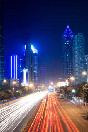 traffic trails on the street with building background at nightの写真素材
