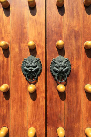 chinese traditional wooden door with beast head knocker の写真素材