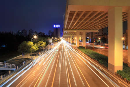 city highway under the viaduct in rush hour traffic at nightの写真素材