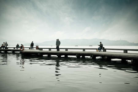 zigzag bridge and tourists on the west lake in hangzhou,Chinaのeditorial素材