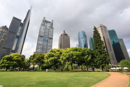 shanghai greenbelt park with modern building in cloudy