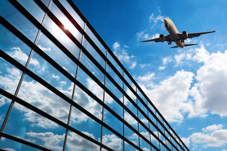 glass curtain wall and aircraft against a blue skyのeditorial素材
