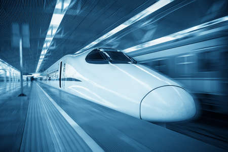 modern high speed train passing railroad station with motion blur effectのeditorial素材