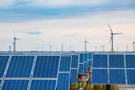 solar and wind power in coastal mud flat, clean energy complementary background.の写真素材