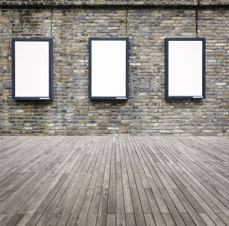 blank advertising light box in the old brick wall with wooden floorの写真素材