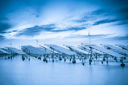solar and wind power in coastal mud flat with blue toneの写真素材