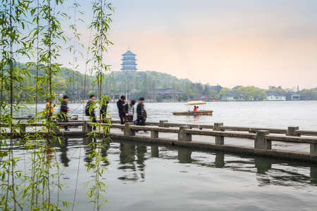 beautiful hangzhou scenery in spring,weeping willow with zigzag bridge and pagoda at dusk,China
の写真素材