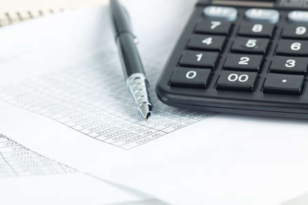 calculator and pen on the financial documents, abstract accounting business concept
