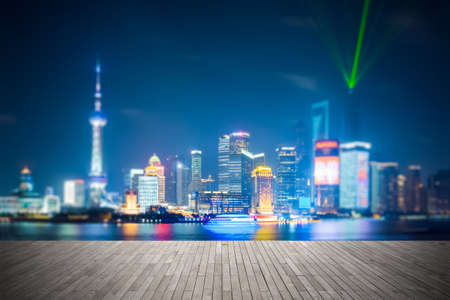 dreamlike city background of shanghai skyline at night , light show with wooden floor prospect