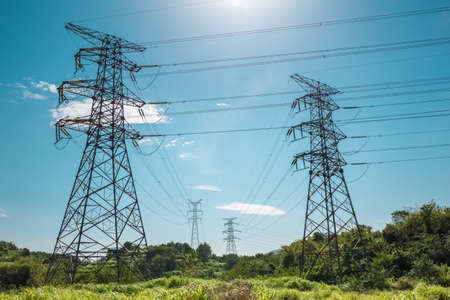 electricity pylon against a blue sky , power transmission background