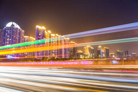 busy city traffic at night in guangzhou with colorful light trailsの写真素材