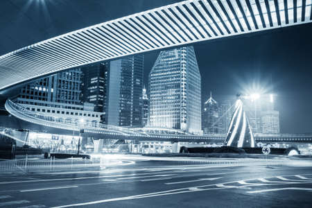 night view of the downtown in shanghai under pedestrian bridge with blue toneの写真素材