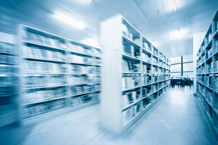 library interior background with radial blur,books on bookshelves and blue toneの写真素材