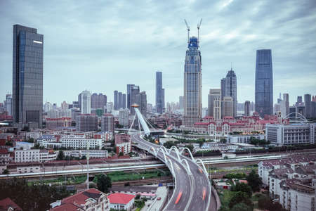 curved viaduct in tianjin ,  train motion blur with modern financial buildingsの写真素材