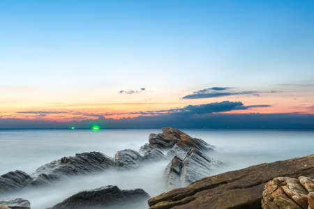 beautiful seascape of rocks with sunset glow over the seaの写真素材