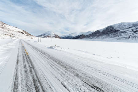 snow covered road with tibetan plateau backgroundの写真素材