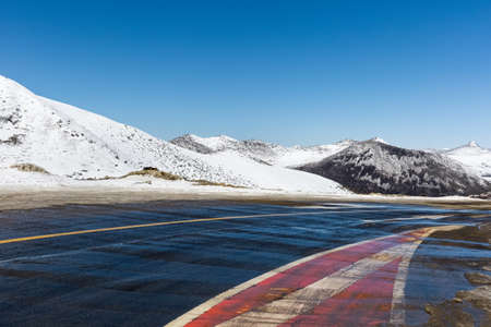 empty road with snow mountain in tibet plateauの写真素材