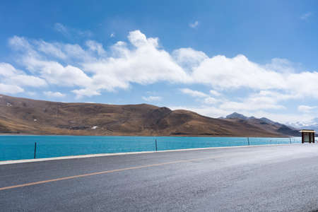 sunlight road and holy lake background on tibet plateauの写真素材
