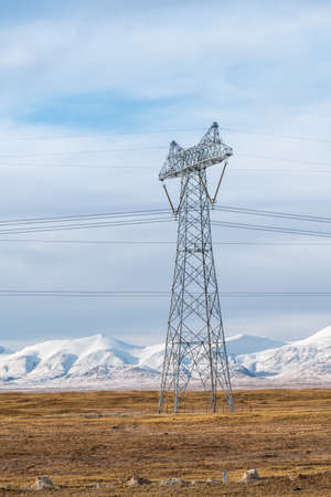 electric power pylon on tibet plateau with snow mountains backgroundの写真素材