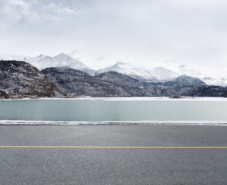 empty asphalt road and snow lake on tibet plateauの写真素材