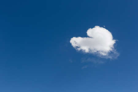 a heart-shaped white cloud on blue sky