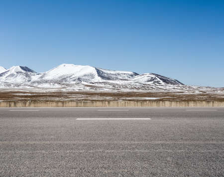 empty asphalt road on snow area plateau, tibetの写真素材