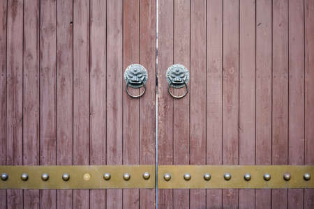 traditional oriental wooden door with lions knockerの写真素材