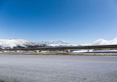 empty asphalt road with snow mountain in tibet plateau, the background is namcha barwa peakの写真素材