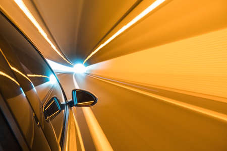 side mirror view of car driving in the tunnel with motion blur