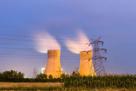 electric transmission pylon with cooling towers at night, long exposure of the thermal power plantの写真素材