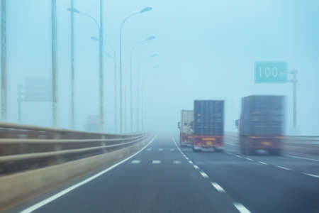 container trucks in fog motion blur on the bridgeの写真素材