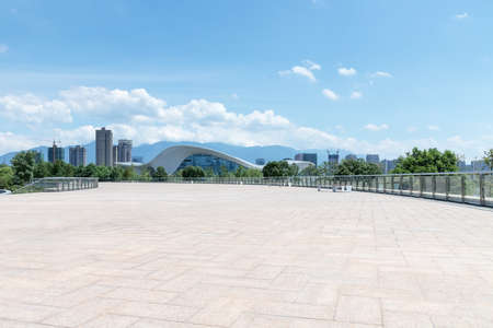 empty brick floor and buildings against a sunny sky