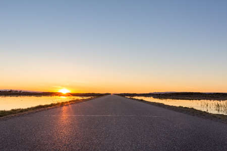 road through the salt lake in sunset, xinjiangの写真素材