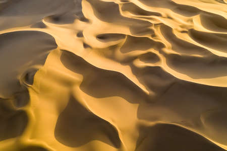 aerial view of desert landscape in sunset, golden sand dunes background texture