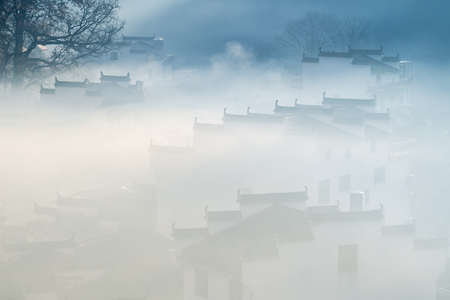 hui style architecture in fog, shicheng village in autumn, wuyuan county, jiangxi province, Chinaの写真素材