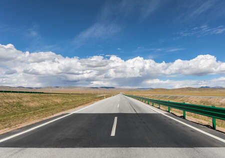 highway on plateau and blue sky, long road stretching out into the distanceの写真素材
