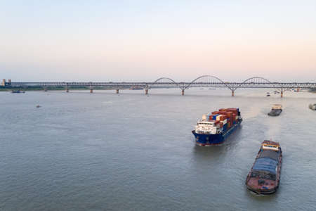 aerial view of container ship on inland river and jiujiang yangtze river bridge, China