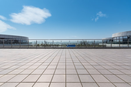 modern cityscape with empty brick floor against a sunny skyの写真素材