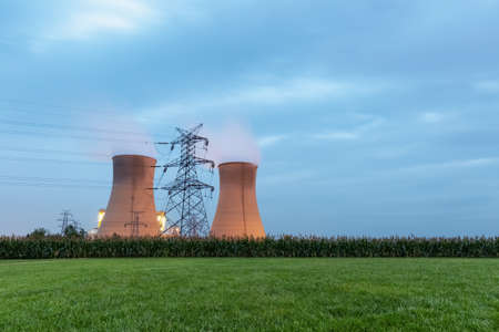 power plant at twilight, cooling towers with green lawn in cloudyの写真素材