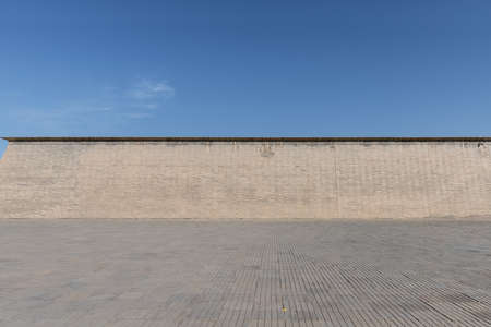 ancient brick wall with blue brick ground against a sunny sky, nice backgroundの写真素材