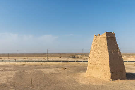 ancient beacon tower by modern highway against a blue sky, Dunhuang city, Gansu province, China.の写真素材
