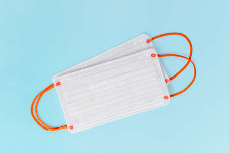 two disposable medical masks isolated on blue backgroundの写真素材
