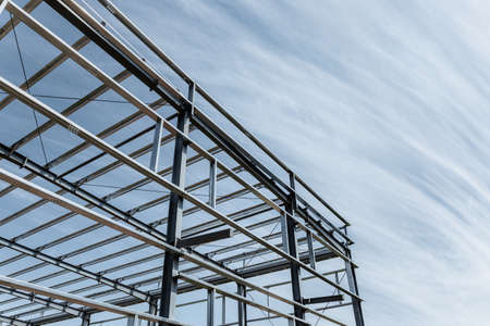 steel frame mill building against a blue sky, steel structure workshop closeupの写真素材