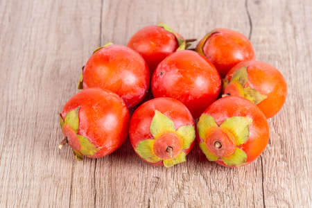 some persimmons arranged on wooden table backgroundの写真素材