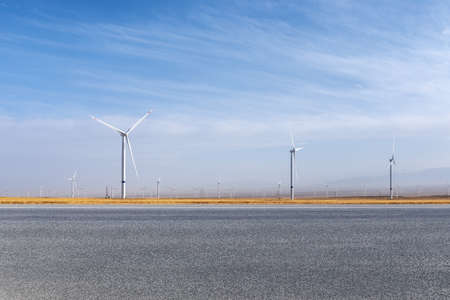 empty asphalt road and wind farm in autumn, highway landscape car travel backgroundの写真素材