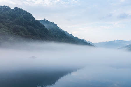 misty river landscape in early morning, fog over the little Dongjiang river, Zixing city, northeast of Chenzhou City, Hunan Province, China.の写真素材