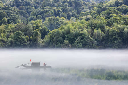 dreamy river scene in summer morning, white fog over the Dongjiang Lake, Zixing city, Hunan Province, China.の写真素材