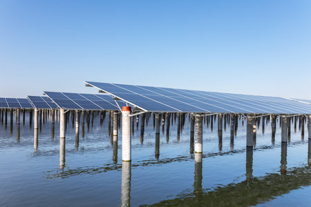 rows of solar panels on the water against a blue sky, renewable energy landscapeの写真素材