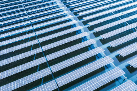 solar panels on blue water surface, aerial view of clean energy landscapeの写真素材